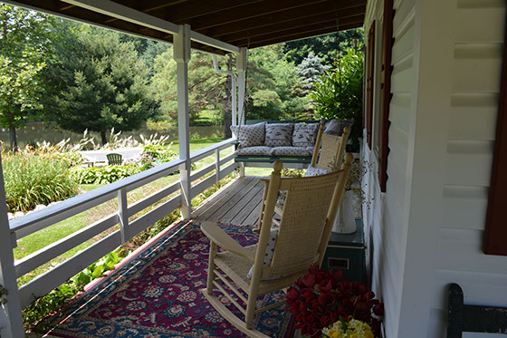 A view from the porch shows swings, rocking chairs overlooking the fishing pond.