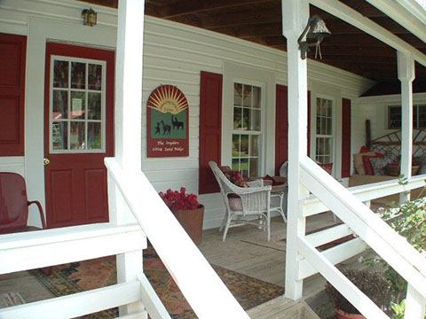 A huge wrap-around porch is perfect for relaxing outside at this cottage for rent.